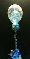 This centerpiee consists of a blue balloon inside of a clear balloon adorned with snowflake designs thatn floats 30 inches above the guest table giving an elegant appearance and not obstructing vision. 