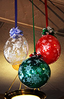 Balloonatics 24 inch diameter Christmas decoration balls are encased in clear long-lasting mylar balloons and serve as an excellent holiday party ceiling decoration