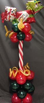 This 24' high centerpiece, combines a red and white candy cane column with an assortment of mylar gift package balloons.