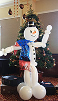 Balloonatics eight foot tall snowman figure sculpture creared from non-round white balloons with black hat to serve as a cheerful greeter to party guests