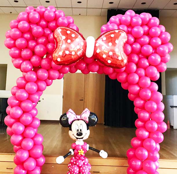 A 20 foot arch made of air filled pink balloons for a Minnie Mouse theme event 