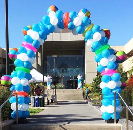 A 15 foot tall summertime fun theme arch with beach balls and float rings for a corporate promotion