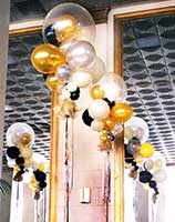 Giant floating bubble decorations using clear, gold, silver and black balloons for a formal event