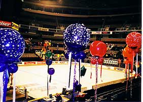 Red and blue 30 inch balloons floating on 8' ribbons serving as area decoration in the arena seating area