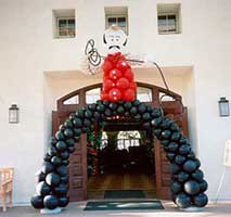 20 foot tall balloon sculpture of a cowboy with lasoo and bowed legs framing the entrance to a wild west theme party