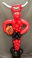 A balloon sculpture ofa six foot tall red bull holding a basketball for a Chicago Bulls theme party