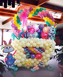 An eight foot tall easter basket sculpted out of lates balloons in pastel colors serves as a focal decoration at an Easter  brunch event.