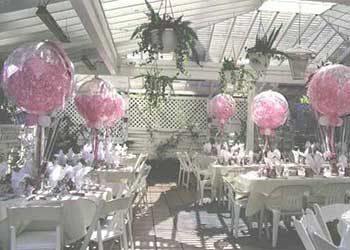 36 inch crystal bubble balloons partially filled with smaller pink balloons serve as a centerpieces for a Mother's Day event.