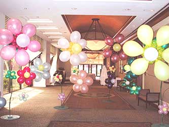 A hall filled with six foot tall ballon fantasy flowers give a garden-like appearance