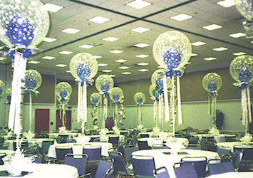 The tables in this room are decorated with clear 30 inch magical bubble balloon centerpieces adorned with white stars with a blue balloon inside each bubble.