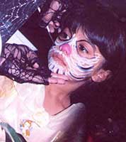 Girl at Halloween party having her face painted as a skeleton