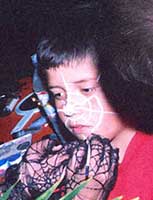 Girl at Halloween party having a spiter web painted on her 