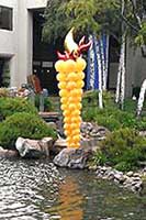 Column created from gold balloons in a tappered design to look like a torch for an outdoor event