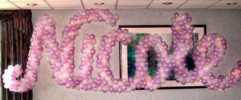 Giant sign spelling out the name of an event celebrant made or swirled balloon letters with interwoven lights